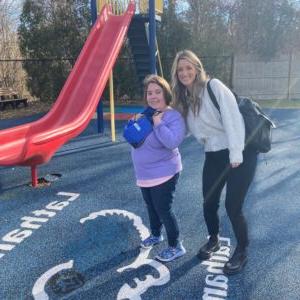 Staff at Latham Centers welcomes new student on her first day 和 shows her the Latham campus playground.